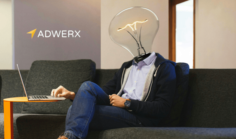A photo-shopped image of a man sitting on a couch using a laptop, with a light bulb for a head